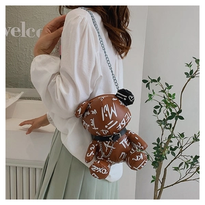 Detail of cute bear crossbody bag with white graffiti and silver metal chain strap