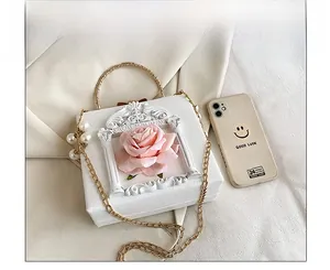 Detail showing white PU leather mini box bag with 3D pink rose and pearl charms