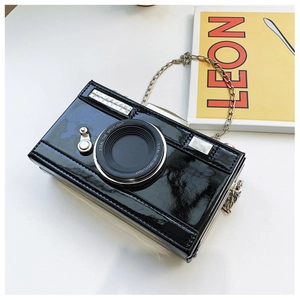 Detail of camera-shaped crossbody bag with glossy patent leather and rhinestone accents
