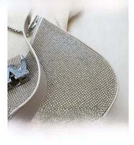 Détails des strass argentés étincelants et du logo V en métal sur le sac à chaîne