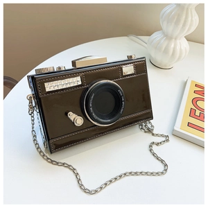 Close-up of dark brown patent leather camera bag with rhinestones and silver chain strap