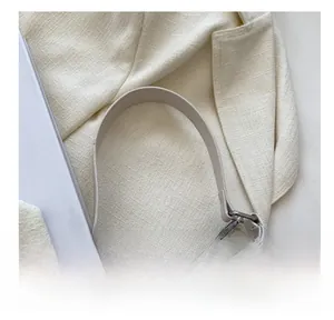 Détails des strass scintillants sur un sac crème avec crochets en métal argenté