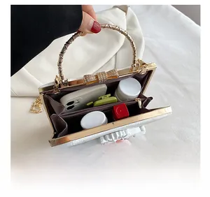 Interior view of white evening bag showing compartments for phone and cosmetics
