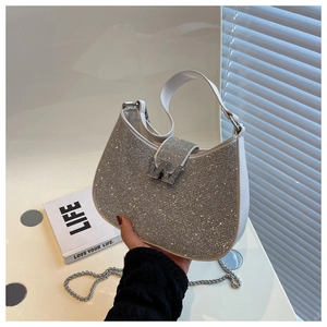 Vue détaillée des strass argentés et de la boucle en métal W sur un sac blanc
