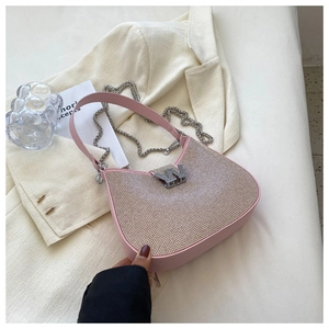 Détail du sac à bandoulière rose clair en strass avec logo W argenté et chaîne