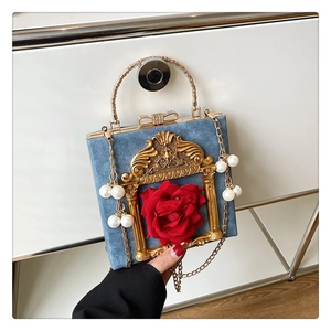 Detail of blue velvet clutch with 3D red rose and pearl-beaded gold chain strap