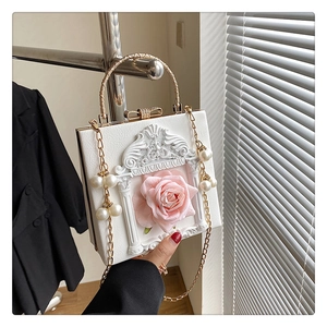 Detail of white 3D rose handbag featuring baroque relief and pearl chain strap