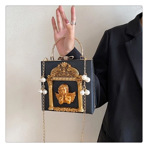 Detail of vintage black box bag with golden cupid relief and ornate baroque frame