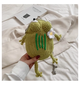 Detail of the green handmade crochet frog purse with metal clasp and silver chain