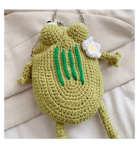 Macro shot of green handmade crochet frog bag showing woven texture and silver metal clasp