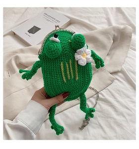 Detail of green handmade knitted frog crossbody bag with silver clasp and metal chain