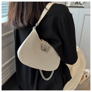Détail du sac selle argenté en strass avec boucle W et bandoulière chaîne à l'épaule
