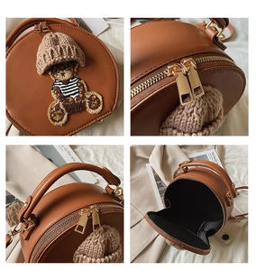 Detailansicht der braunen runden Handtasche mit Teddybär-Design und goldenen Beschlägen