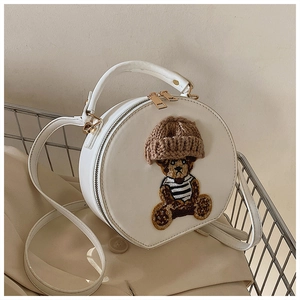 Detailansicht einer runden weißen Handtasche mit 3D-Bär und gestrickter Mütze