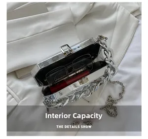 Internal capacity of silver mirror acrylic box bag showing sunglasses and lipstick