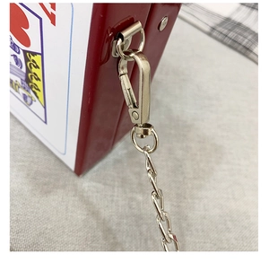 Macro shot of bright red box bag showing silver metal clasp and fine chain strap detail