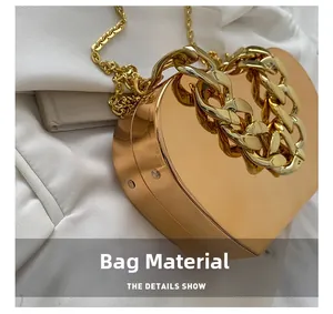 Detail view of heart-shaped gold metallic evening bag with polished mirror finish and chain