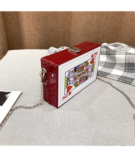 Detailed view of red patent leather box bag with King of Hearts poker print and chain