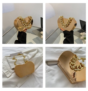 Detail of gold heart-shaped metal evening bag with chunky chain handle and mirror finish