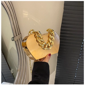Detailed close-up of a heart-shaped metallic gold clutch with chain handle and strap