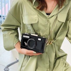 Fashionable black camera-shaped crossbody bag with glossy finish and chain strap