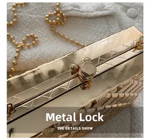 Detail of golden metal clutch bag with geometric grid texture and spherical hardware clasp