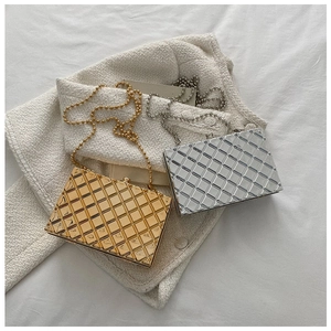 Detail of gold and silver metal clutch bags with quilted texture on tweed fabric