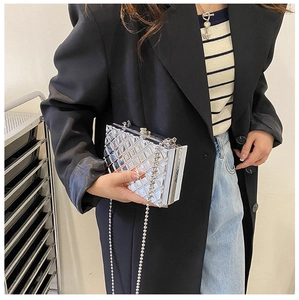 Detail of silver metallic box bag featuring a 3D geometric quilted pattern and chain