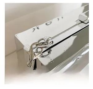 Close-up of shiny silver quilted evening clutch showing metal chain and clasp details