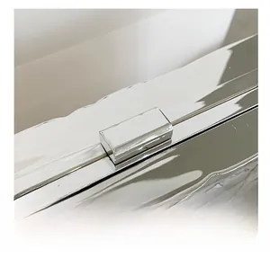 Close-up of a silver mirror-finish metal lock buckle on a luxury clutch handbag