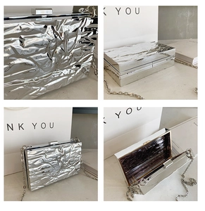 Detail of silver metallic clutch with crinkled texture and silver square clasp closure