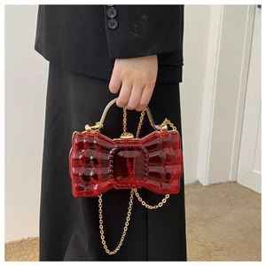 Vue détaillée d'une pochette nœud en acrylique rouge vif avec chaîne et poignée dorée
