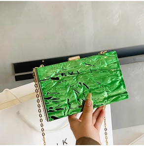 Detail of bright green handbag featuring unique metallic crinkle texture and gold clasp
