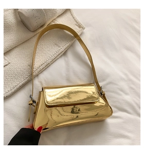 Detail of trendy metallic gold shoulder bag with high-gloss mirror finish and flap closure