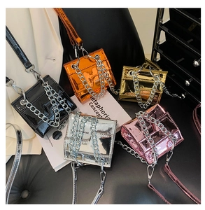 Gros plan de mini sacs en cuir verni métallisé avec décoration de chaîne à gros maillons