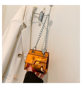 Détail du mini sac orange métallisé brillant avec chaîne argentée et logo embossé