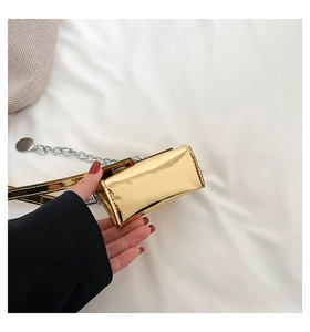 Détail du mini sac à main doré avec finition miroir brillante et bandoulière chaîne