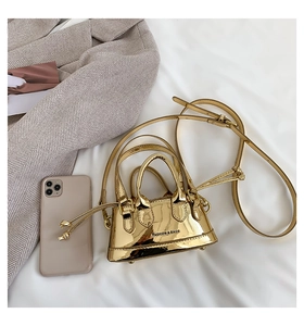 Detail of micro gold patent leather bag with metal finish and Fashion & Bags text