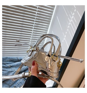 Close-up of metallic silver mini bag with gold engraving and adjustable strap detail