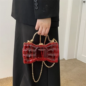 Sac à main transparent rouge en forme de nœud avec poignée dorée et bandoulière