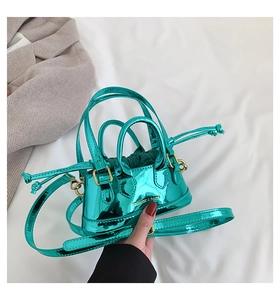 Close-up of metallic green patent leather mini shell bag with fashion lettering and drawstrings