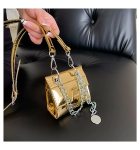 Vue détaillée du mini sac doré brillant avec sa chaîne décorative en métal argenté épais