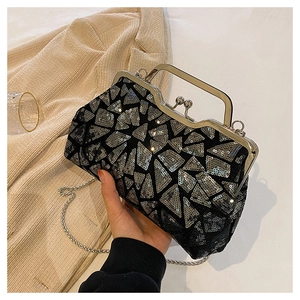 Close-up of black sequined evening clutch with silver geometric patterns and metal handle