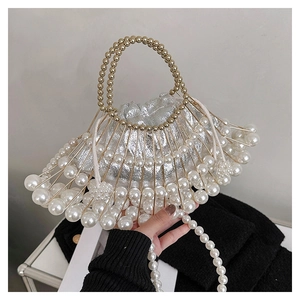 Detail of fan-shaped evening bag featuring pearls, gold metal frame and pearl strap