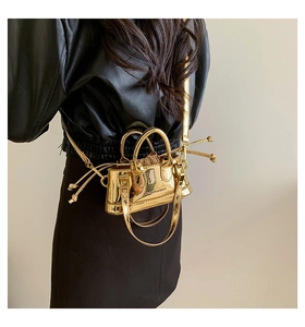 Detail of metallic gold mini bag with FASHION & BAGS text and glossy finish