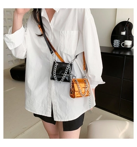Détail de mini sacs carrés en cuir verni brillant avec bandoulières chaîne en argent
