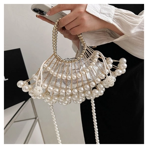 Detail of fan-shaped evening bag featuring white pearls and gold metal frame structure