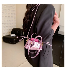 Close-up of metallic pink mini handbag with woven handles and fuchsia drawstring insert
