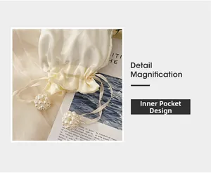 Detail of cream satin inner pouch with drawstring and decorative pearl ball accents