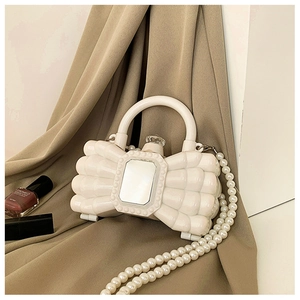 Dettaglio borsa da sera in acrilico bianco con catena di perle e chiusura in cristallo